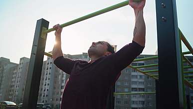 A Man Using An Outdoor Monkey Bar To Do Pull-up Exercise Free